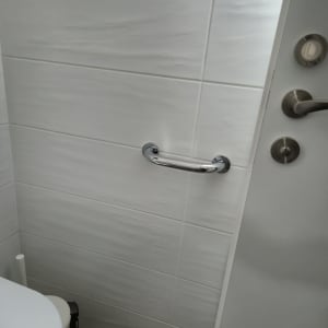 ידית אחיזה מותקנת על קיר אריחים בחדר אמבטיה