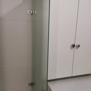 מקלחון עם דלת זכוכית ומכונת כביסה