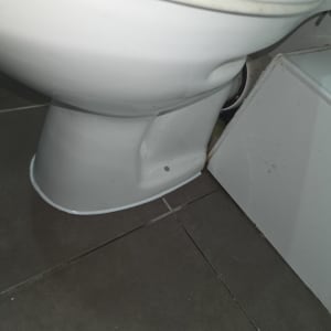 אסלה לבנה על רצפת אריחים אפורה