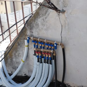 צנרת מים על קיר חיצוני עם ברזים וצינורות