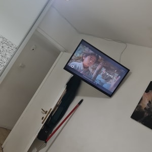 מטאטא אדום נשען על קיר ליד דלת לבנה