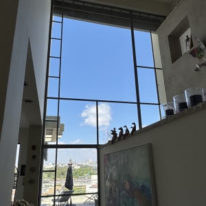חלון גדול עם נוף לעיר ושולחן אוכל