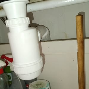 צינור ניקוז לבן מתחת לכיור עם פומפה