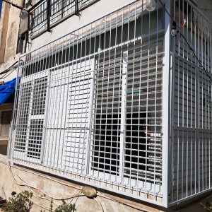 סורגים לבנים מותקנים על חלונות בניין