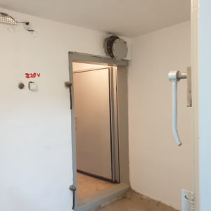 קיר צבוע בלבן עם דלת אפורה פתוחה