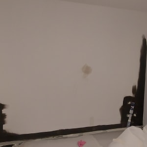 קיר עם סימני צבע כהה בתהליך צביעה