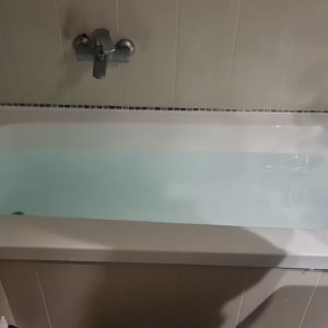 אמבטיה עם מים, ברז קיר, אריחים לבנים