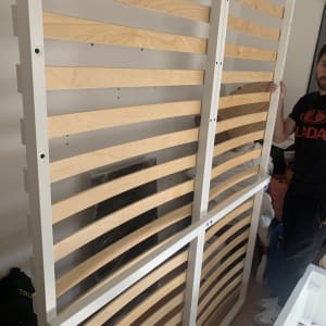 מסגרת מיטה מעץ ומתכת מוחזקת על ידי אדם