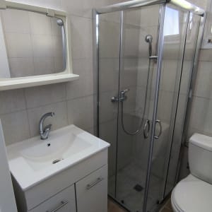 מקלחון זכוכית עם דלתות מתכת וברז מקלחת