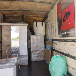 תכולת משאית עם רהיטים וארגזים עטופים בניילון