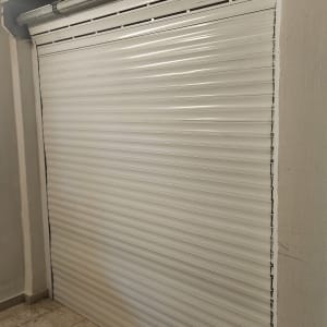 תריס גלילה לבן סגור עם מנגנון מתכת עליון