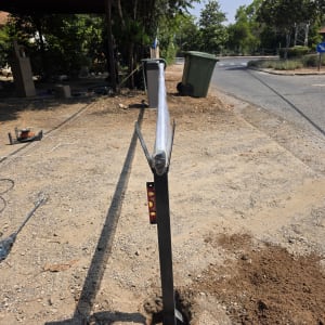 שער חשמלי מותקן על שביל עפר עם כלים מסביב