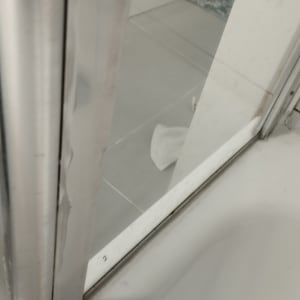 דלת מקלחת מזכוכית עם מסגרת מתכת