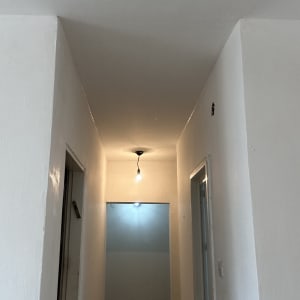 מסדרון צבוע בלבן עם נורה תלויה