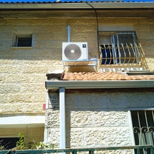יחידת מיזוג אוויר מותקנת על קיר חיצוני של בית