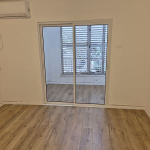 תריסים לבנים על חלון זכוכית בחדר פנימי