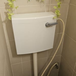 אסלה עם מיכל הדחה וצינור מים