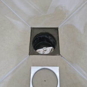 תמונה של חור ניקוז ברצפה עם מכסה מתכת