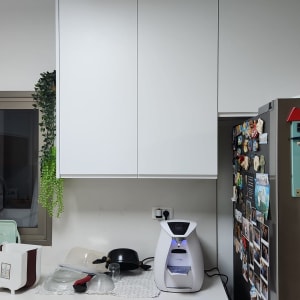 מטבח עם ארונות לבנים ומקרר עם מגנטים