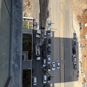 מבט מלמעלה על מנוף וכלי רכב באתר בנייה