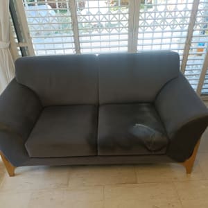 ספה אפורה עם כתמים על הריפוד