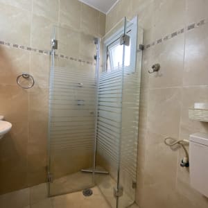 מקלחון זכוכית עם דלתות שקופות וראש מקלחת