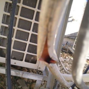 צינורות ומזגן חיצוני על רקע אבנים