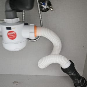 צנרת מתחת לכיור עם מחבר פלסטיק לבן