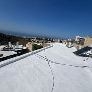 גג אטום בלבן עם קולטי שמש וצינורות