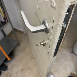 ידית דלת מתכתית ומנעול על דלת עץ