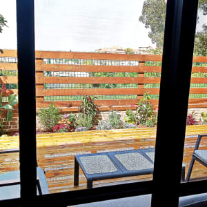 גינה עם צמחים ופרחים ליד גדר עץ