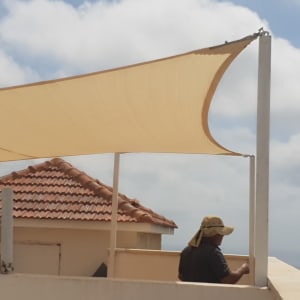 סוכך בד מתוח על עמודים במרפסת גג