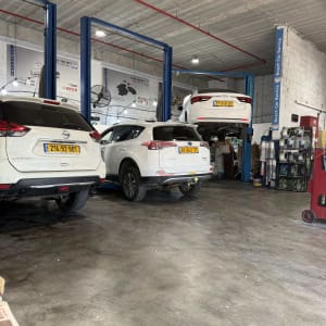 מוסך עם רכבים על ליפטים, כלי עבודה וציוד תחזוקה