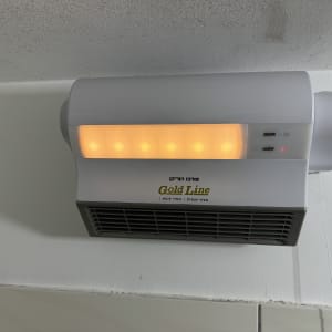 תנור חימום חשמלי מותקן על קיר עם כבל חשמל