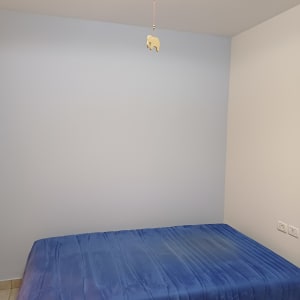 קיר צבוע בצבע כחול עם מיטה בחדר