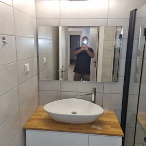 כיור אמבטיה עם מראה וקיר אריחים