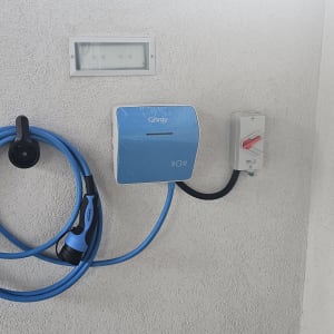 מטען לרכב חשמלי מותקן על קיר עם כבל כחול