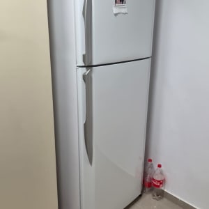 מקרר ביתי לבן שעומד במקומו בבית