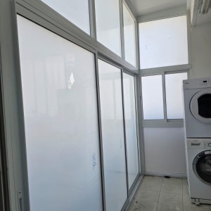 חדר עם דלתות וחלונות אלומיניום ומכונת כביסה