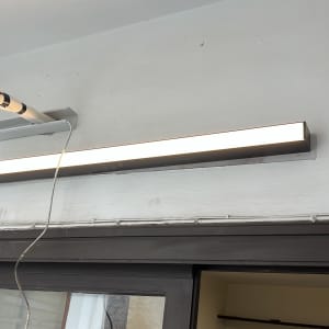 מנורת פלורסנט מותקנת על קיר עם חוטי חשמל