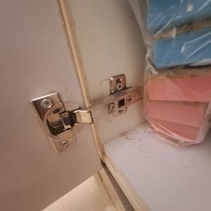 ציר מתכת בארון מטבח עם ספוגים צבעוניים