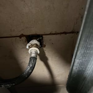 צינור שחור מחובר לקיר עם חיבור מתכתי