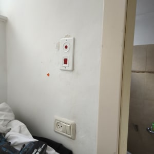 מתג חשמלי ומקדחה על קיר לבן