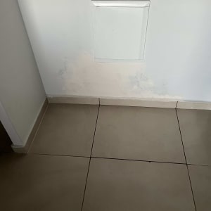 קיר עם תיקון טיח מעל אריחי רצפה