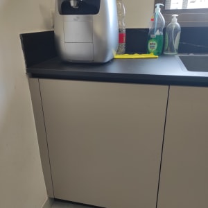 מכונת קפה על משטח מטבח עם חומרי ניקוי