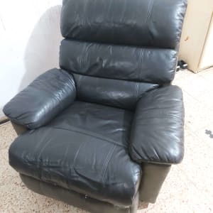 כורסה שחורה מעור עם משענות מרופדות