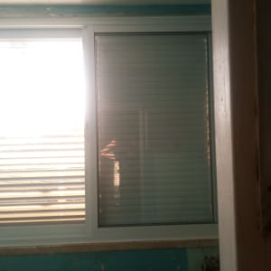 חלון אלומיניום עם תריסים בחדר מואר