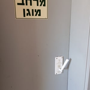 ידית דלת לבנה על דלת אפורה