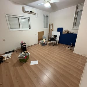 חדר ריק עם רצפת עץ וחפצים מפוזרים