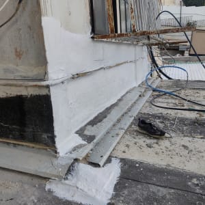 איטום קיר חיצוני עם חומר לבן ליד חלון